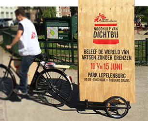 De aankondiging op fiets-aanhangers voor Noodhulp van Dichtbij, ontworpen door Reclamebureau Gedachtegoed